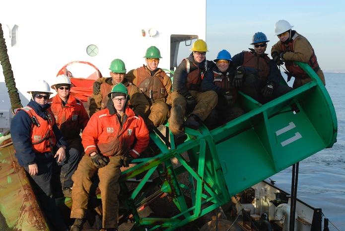 Members of the deck crew of the Coast Guard Cutter Juniper pose on a buoy for a group photo before returning the buoy to sea in the Sandy Hook Channel Thursday, Dec. 7, 2006.