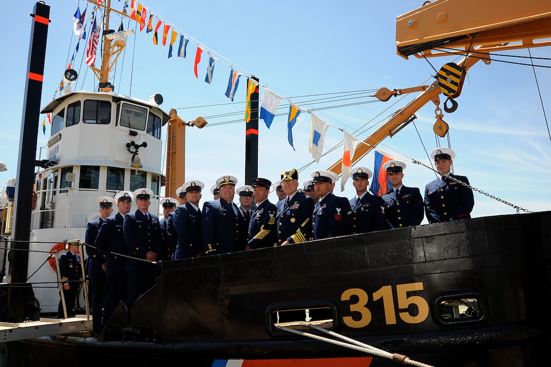 Coast Guard Commandant and Gold Ancient Mariner Adm. Bob Papp and Silver Ancient Mariner Master Chief Petty Officer Steven Hearn pose with the crew of Coast Guard Cutter Smilax after a relief of watch ceremony in Atlantic Beach, N.C., April 14, 2011.