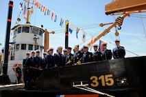 Coast Guard Commandant and Gold Ancient Mariner Adm. Bob Papp and Silver Ancient Mariner Master Chief Petty Officer Steven Hearn pose with the crew of Coast Guard Cutter Smilax after a relief of watch ceremony in Atlantic Beach, N.C., April 14, 2011.