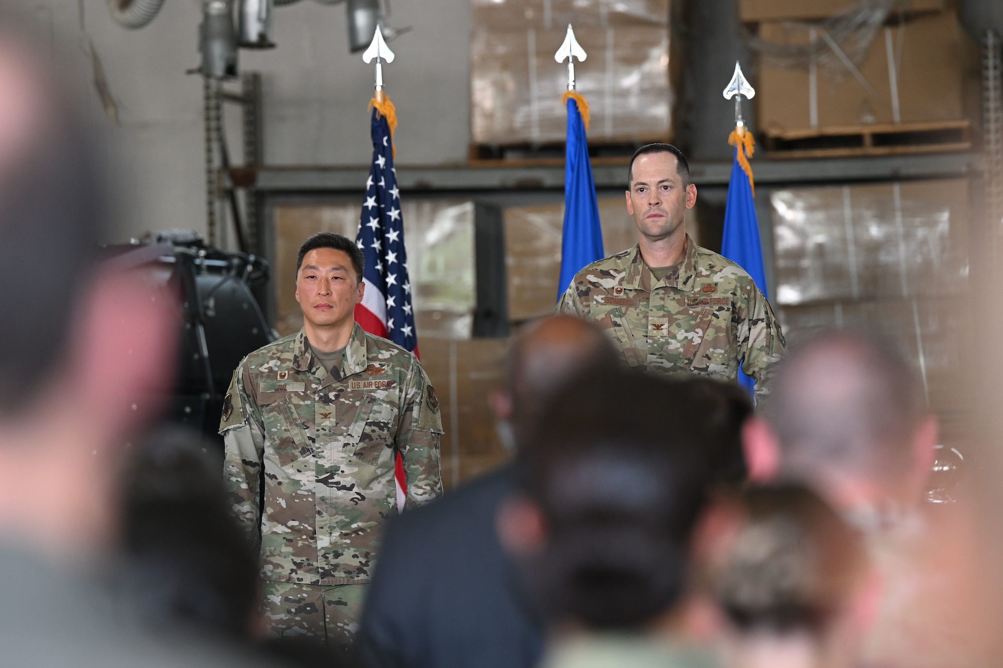 Two military members standing in front of a crowd.