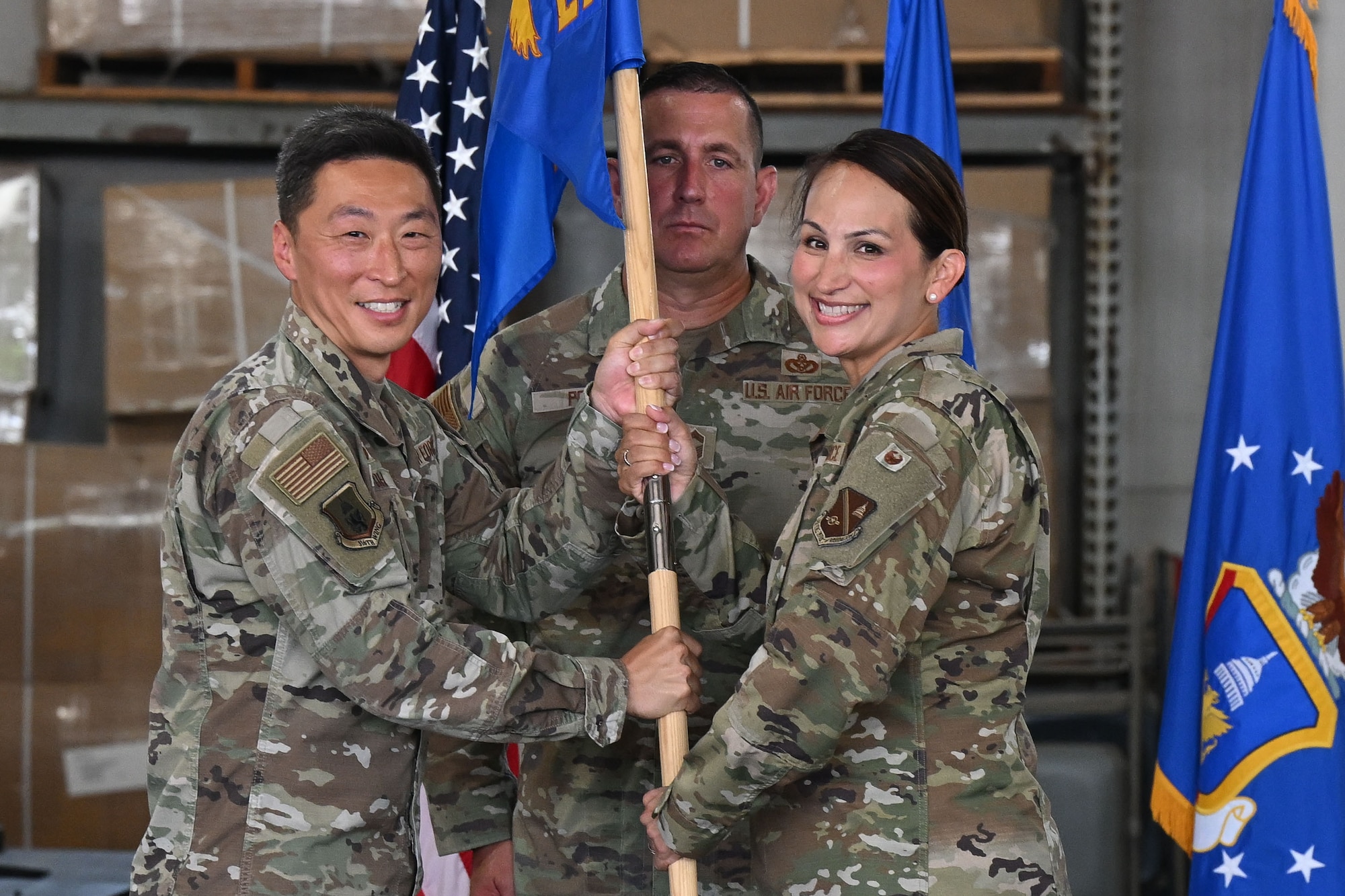 Military members holding a blue flag.