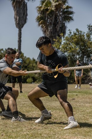 U.S. Marine Corps Cpl. Joshua Dreher, combat graphics specialist, communication strategy and operations, right, and Cpl. Matthew Shelton, musician with Marine Band San Diego, left, both with Headquarters and Service Battalion, Marine Corps Recruit Depot San Diego, help their team during the tug of war event during the Headquarters and Service Battalion Atlas Games at MCRD San Diego, California, July 2, 2024. The H & S Atlas Games is a battalion field meet that incorporates leadership skills and team work to enhance individual readiness, unit cohesion, boost morale and foster esprit de corps among Marines. (U.S. Marine Corps photo by Lance Cpl. Alexandra M. Earl)