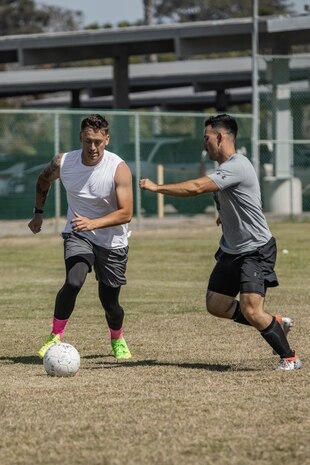 U.S. Marine Corps Sgt. Jesse Carter-Powell, operations chief for communication strategy and operations, left, Cpl. Matthew Shelton, musician with Marine Band San Diego, right, both with Headquarters and Service Battalion, Marine Corps Recruit Depot San Diego, compete in a soccer game during the Headquarters and Service Battalion Atlas Games at MCRD San Diego, California, July 2, 2024. The Atlas games is a battalion field meet that incorporates leadership skills and team work to enhance individual readiness, unit cohesion, boost morale and foster esprit de corps among Marines. (U.S. Marine Corps photo by Lance Cpl. Alexandra M. Earl)