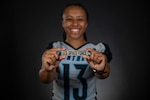 A woman in a football jersey holds a U.S. Space Force name tape towards the camera.