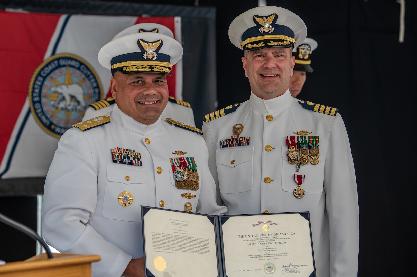 U.S. Coast Guard Capt. Keith M. Ropella receives the Meritorious Service Medal from Vice Adm. Andrew Tiongson who is holding the written award in front of both of them.