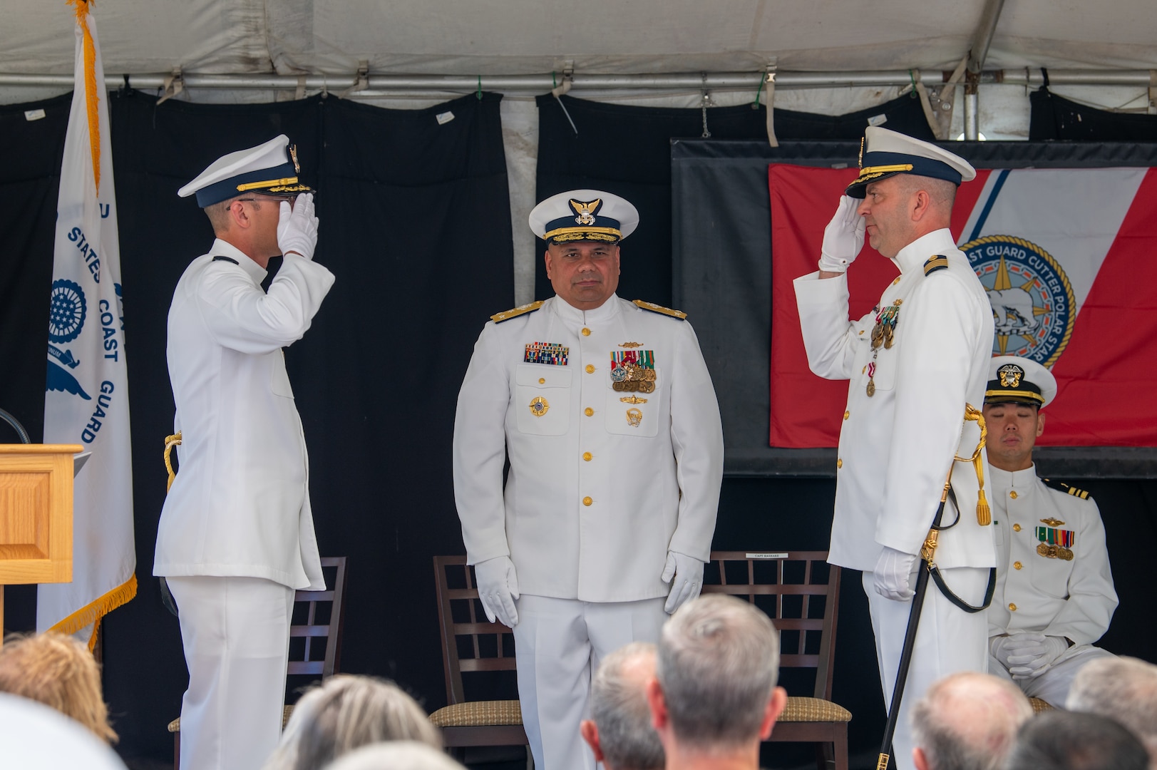 U.S. Coast Guard Capt. Jeffrey Rasnake salutes Capt. Keith Ropella with Vice Adm. Andrew Tiongson standing between them.