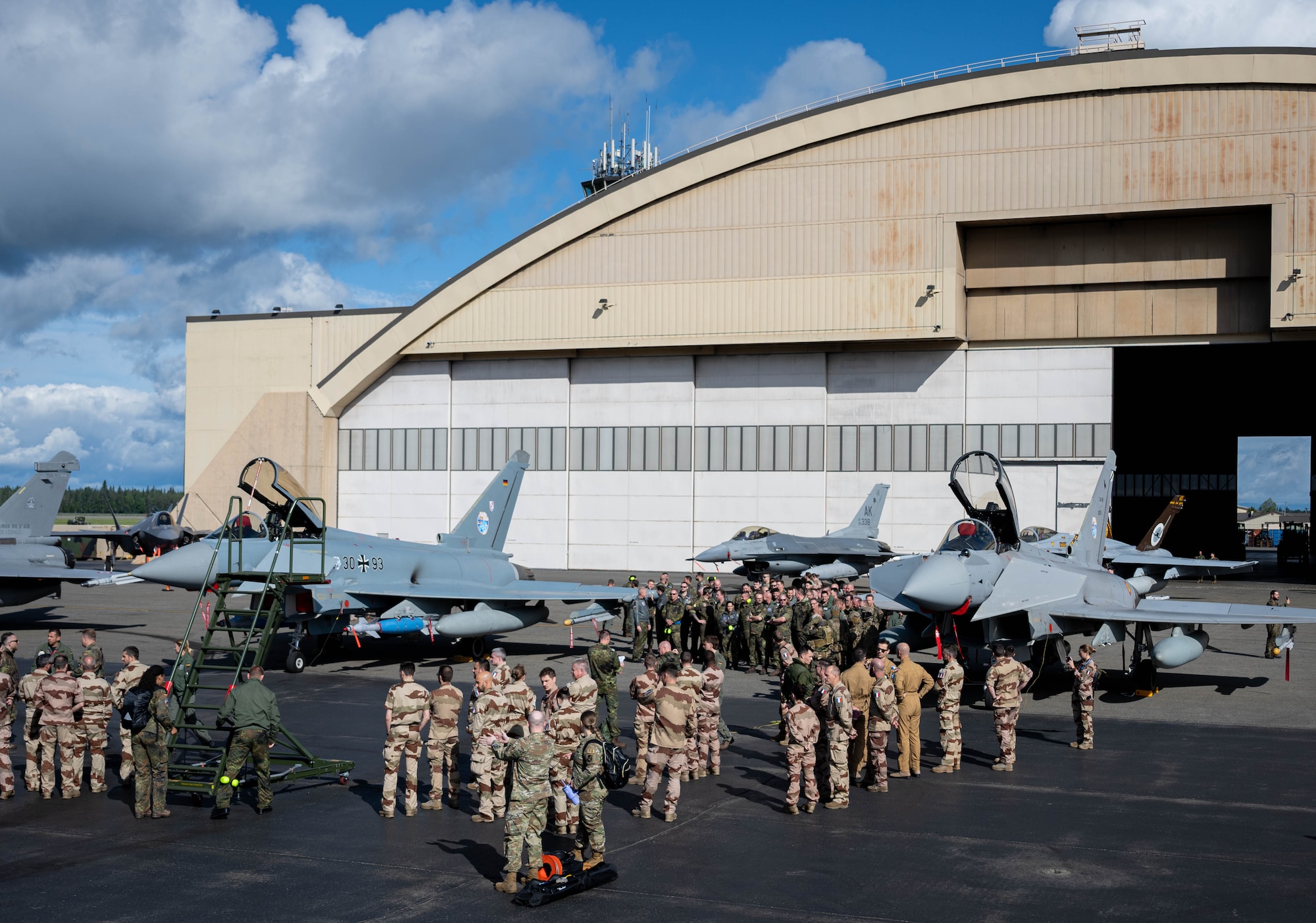 Armed forces members from the U.S., Germany, France and Spain view static display aircraft.