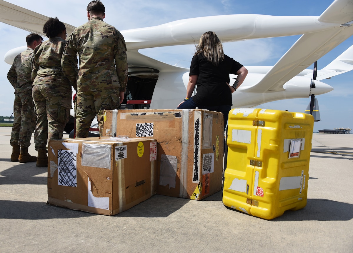Alyxandra Scalone, 305th Maintenance Squadron Production Controller (right), and her Precision Measurement Equipment Laboratory team prepare to load cargo on BETA Technologies’ prototype, ALIA CTOL, a battery-powered fixed-wing aircraft at Joint Base McGuire-Dix-Lakehurst, N.J., July 9, 2024. This is the first demonstration of the aircraft’s cargo capabilities. BETA partnered with AFWERX Agility Prime to test the capabilities of moving cargo between bases in a safer, cleaner, and more cost-effective way. (U.S. Air Force photo by Master Sgt. Joseph Vigil)
