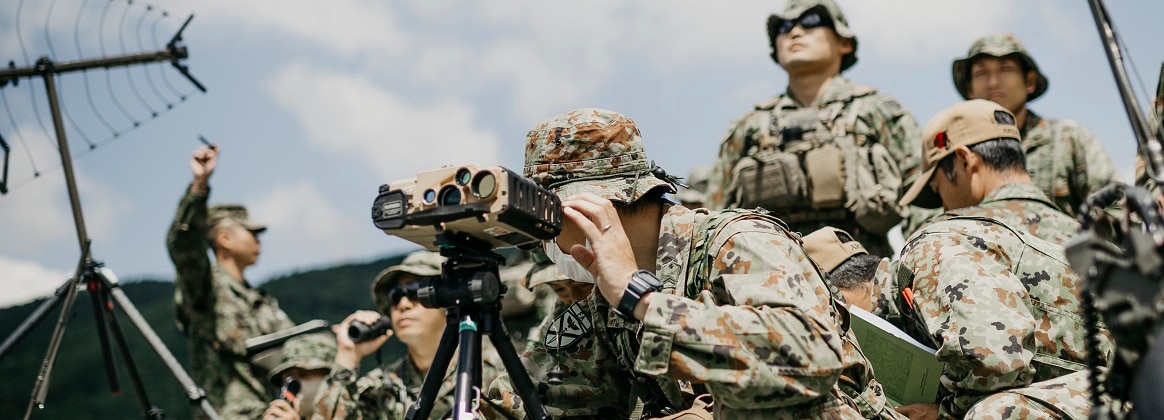 Japan Ground Self-Defense Force service members with Field Leading Company, Field Artillery Battalion, Amphibious Rapid Deployment Brigade, observe aircraft overhead during a subject matter exchange between 5th Air Naval Gunfire Liaison Company.