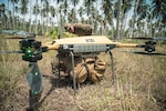 U.S. Marines inspect a load of cargo secured to a Tactical Resupply Unmanned Aircraft System before flight at a coastal defense site during Archipelagic Coastal Defense Continuum on Kamuning Beach, Palawan, Philippines, May 15, 2024. The TRUAS is a Class 3 unmanned aerial vehicle that can deliver supplies to remote and inaccessible areas. CLB-15 is employing the TRUAS as part of experimentation for expeditionary resupply concepts. (U.S. Marine Corps photo by Cpl. Joseph Helms)