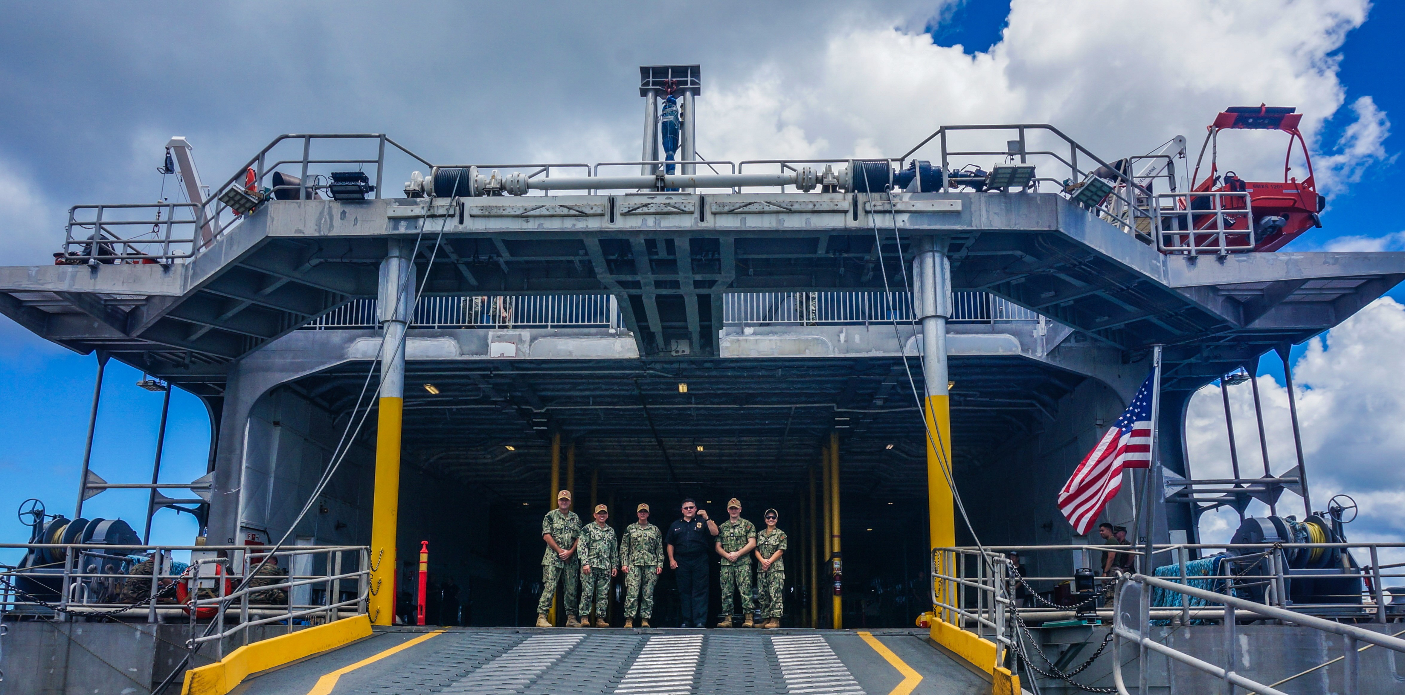 The group from USNHO in front of the Open hull of the USNS Guam