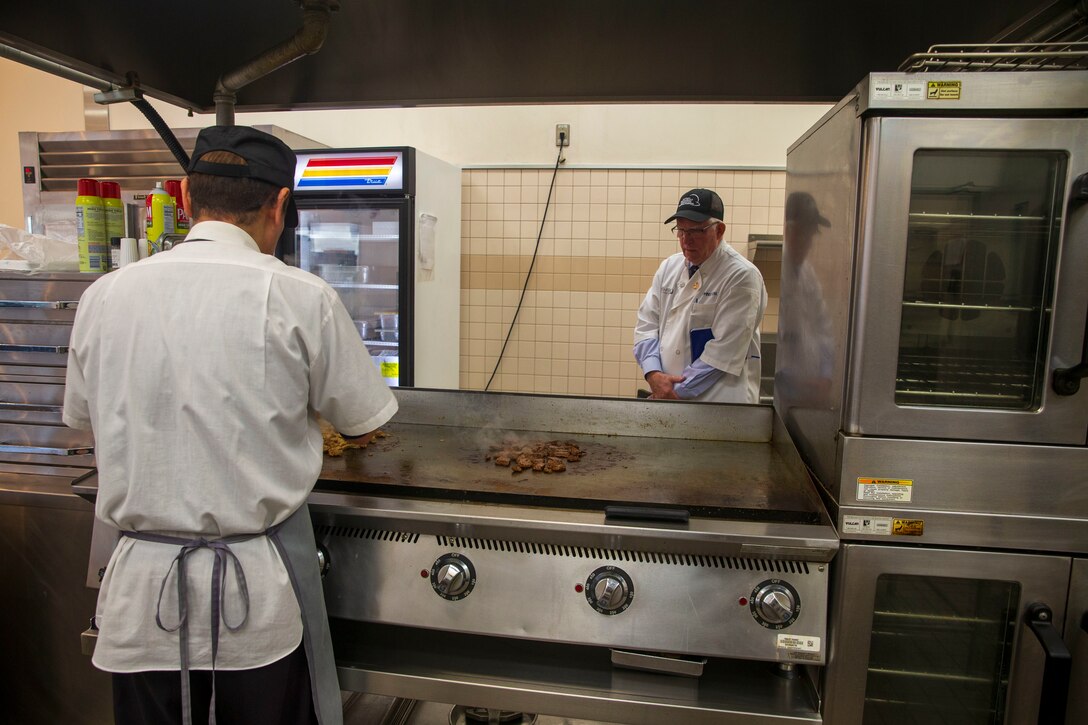Mike Johnston, a member of the National Restaurant Association Education Foundation, inspects the cooking procedures of the Flight Line Mess Hall at Marine Corps Air Station Iwakuni, Japan, as part of the Maj. Gen. William Pendleton Thompson (W.P.T.) Hill memorial awards program, Jan. 29, 2024. The W.P.T. Hill awards program aims to acknowledge outstanding performance within Marine Corps food service operations, including determining and recognizing the best mess halls of the year.