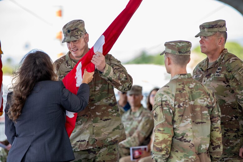 Lt. Col. Christopher “Ryan” Pevey, outgoing District Commander for the U.S. Army Corps of Engineers Honolulu District, receives the unit colors from the Deputy District Engineer for Programs & Project Management Jennifer Moore, before symbolically relinquishing command by passing the unit colors to Brig. Gen. Joseph C. “Clete” Goetz II, Commanding General for the U.S. Army Corps of Engineers Pacific Ocean Division in a July 10 ceremony aboard the Battleship Missouri Memorial.