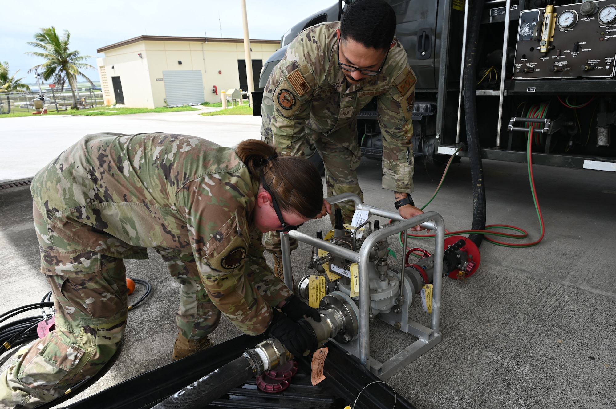 Two Airmen work together to separate the Versatile Integrating Partner-Nation Equipment Refueling hose from the kit.