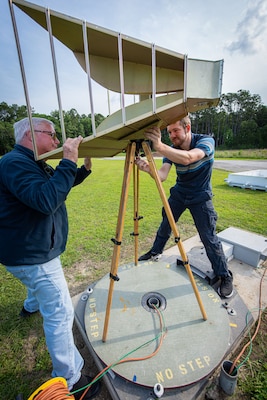 Bill Warner and Daniel Smith are setting up one of the reference antennas on the composite turntable. The composite turntable is a common tool used in RF testing to measure the radiation pattern of an antenna in two dimensions. After completing 2D antenna pattern measurements on a standalone antenna, the composite turntable is typically used for more detailed testing. (