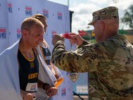 U.S. Army Maj. Gen. John D. Kline, Commanding General of the United States Army Center for Initial Military Training, United States Army Training and Doctrine Command, right, presents the silver medal to Sgt. 1st Class Jeffrey Peters in a medal ceremony at the track event during the 2024 Department of Defense Warrior Games