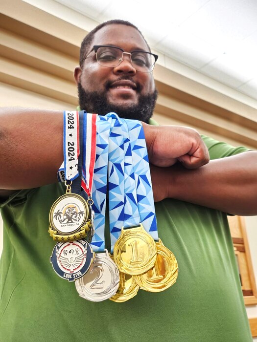 closeup of Jay with six medals hanging from his crossed right arm.