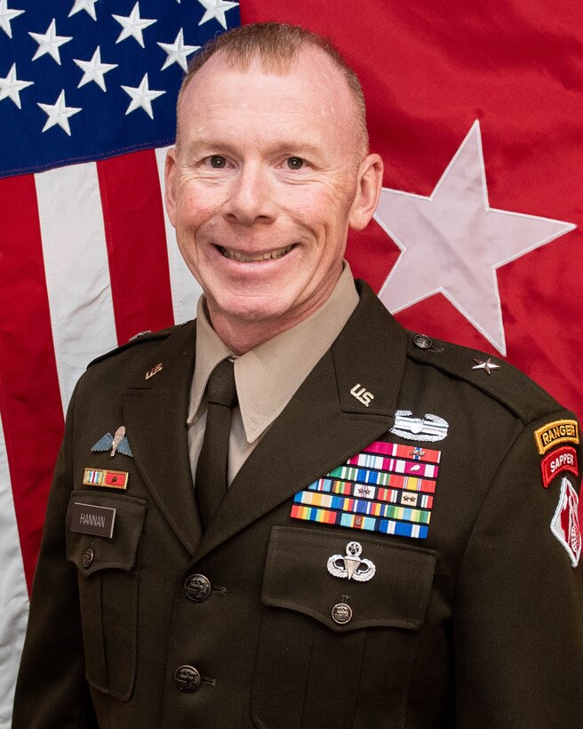 Army General in uniform in from of flag