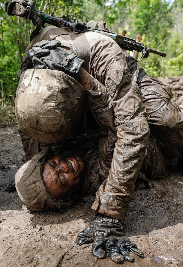 Recruit Tyler Edmunds neck drags Recruit Oluwagbemiga Omotoye, recruits with Echo Company, 2nd Recruit Training Battalion, to safety during the Noonan’s Casualty Evacuation event during the Crucible on Marine Corps Recruit Depot Parris Island, S.C., June 28, 2024. The event is in honor of Lance Cpl. Thomas Noonan, a Vietnam era Medal of Honor recipient, and includes recruits conducting combat patrols and casualty evacuations.  (U.S. Marine Corps photo by Lance Cpl. William Horsley)