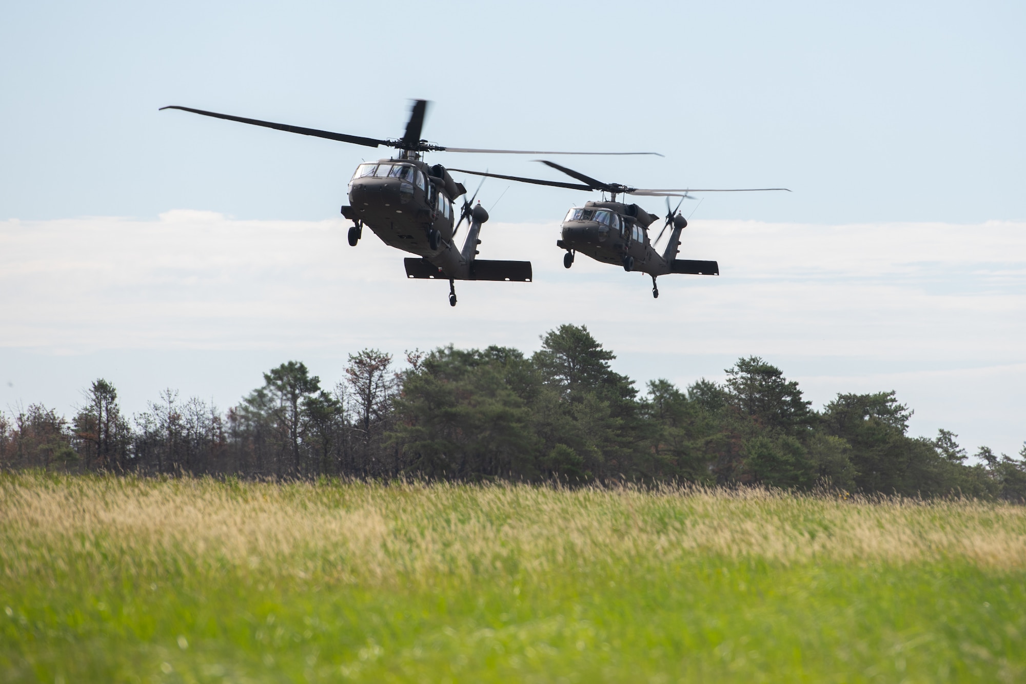 Airmen assigned to the 171st Civil Engineer Squadron and the 177th Civil Engineer Squadron arrive aboard UH-60 Black Hawk helicopters to perform land navigation and simulated combat training exercises as part of the Piney Devil training exercise on June 9, 2024, at Warren Grove Range, New Jersey.