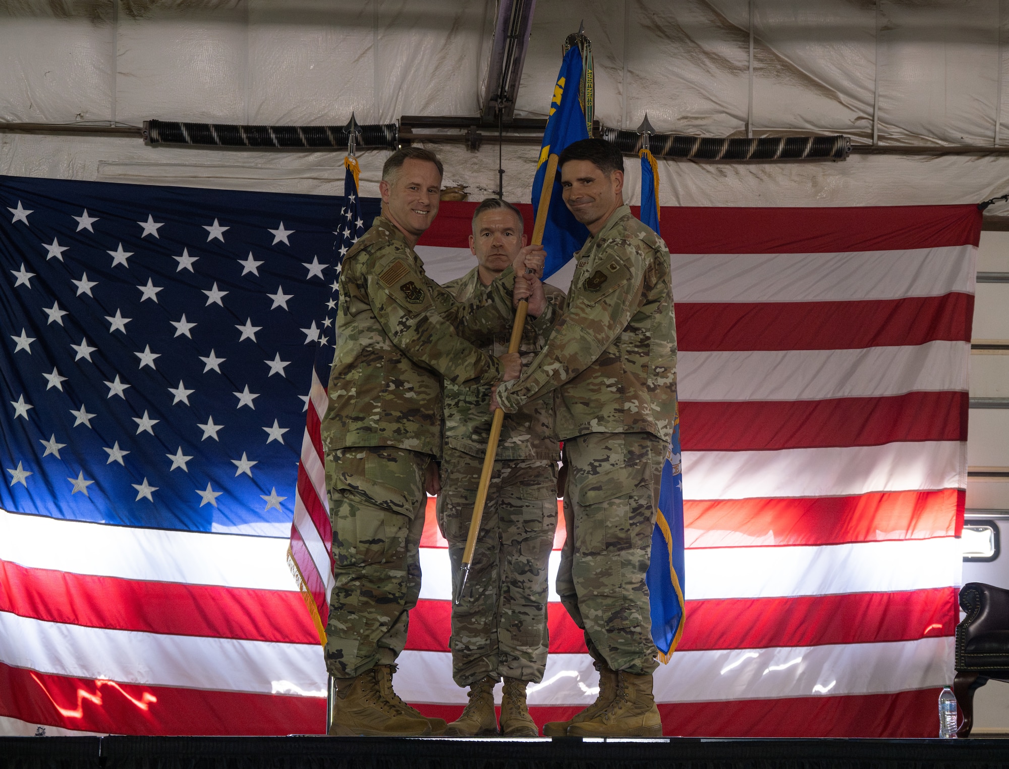 U.S. Air Force Col. James Schlabach, 91st Missile Wing commander, passes the guidon to U.S. Air Force Col. Mike Suden, 91st Operations Group (OG) commander, during the 91st OG assumption of command ceremony at Minot Air Force Base, North Dakota, July 10, 2024. Schlabach gave the guidon to Suden during the ceremony, symbolically passing command of the 91st OG. (U.S. Air Force photo by Airman 1st Class Alyssa Bankston)
