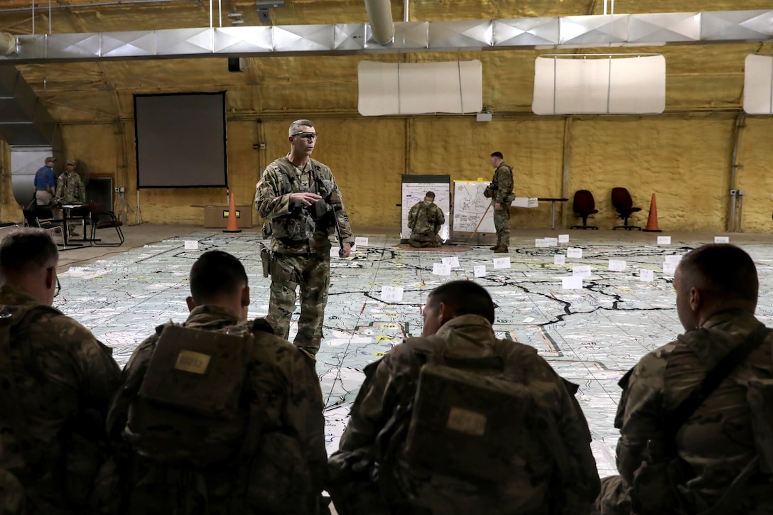 Col. Matthew Elder, commander of the Wisconsin Army National Guard’s 32nd Infantry Brigade Combat Team, leads a combined arms rehearsal with battalion leadership June 3 during a rotation at the Joint Readiness Training Center, Fort Johnson, La. Combined arms rehearsals create a shared understanding of the mission by having different elements of the brigade talk through their assignment, using a large floor map to show their location and movement in relation to other brigade elements. Battalions and companies conducted their own rehearsals to ensure all leaders had an understanding of their part of the mission. The Red Arrow led more than 5,000 Soldiers from across the United States and Canada in simulated large-scale combat operations. This realistic training builds readiness for overseas deployments and prepares Soldiers to survive the rigors of war. 32nd IBCT photo by Staff Sgt. Kati Volkman