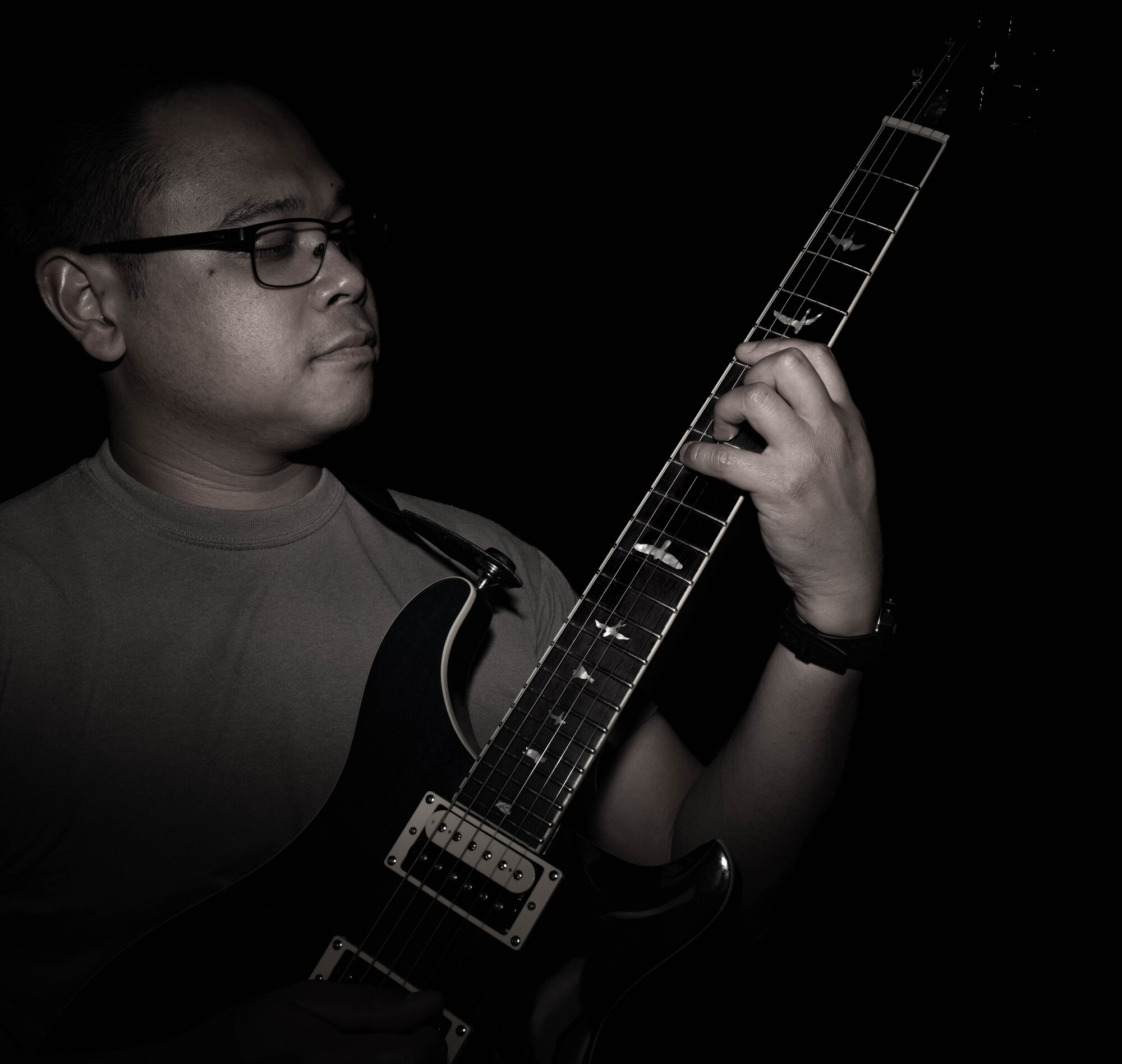 U.S. Air Force Master Sgt. Jonathan Salvador, 705 Munitions Squadron non-commissioned officer in charge, practices chords on a guitar in a studio on Minot Air Force Base, North Dakota, July 9, 2024. Salvador has been playing guitar since he was 10 years old, he continues to play music each and every day. (U.S. Air Force photo by Senior Airman Alexander Nottingham)