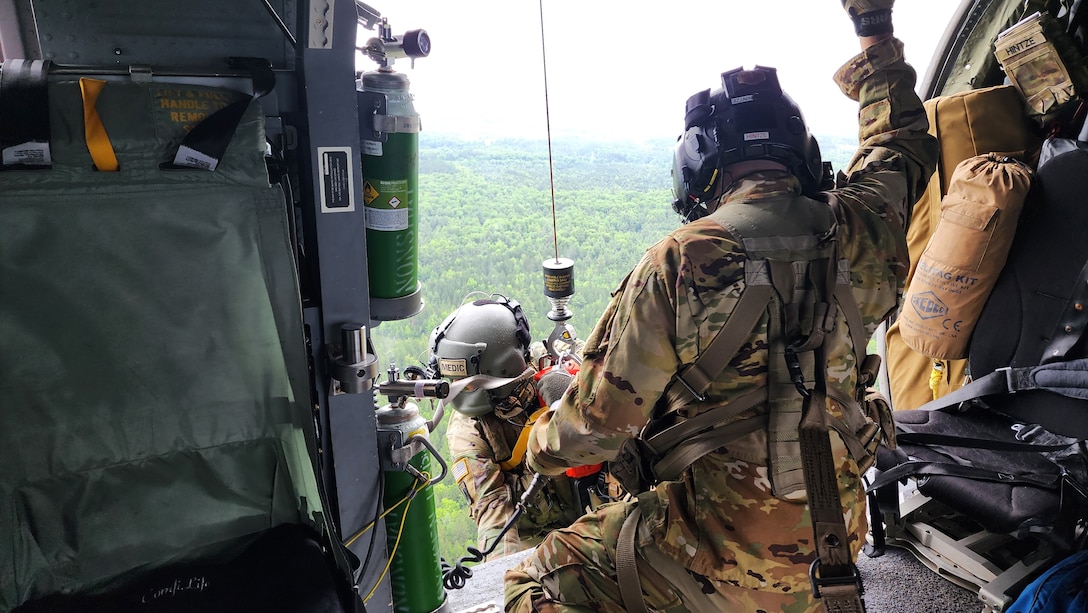 Sgt. Zachary Hintze, a crew chief assigned to a Wisconsin Army National Guard UH-60 Black Hawk crew from West Bend, Wis., hoists Sgt. 1st Class Eric Furbee, a critical care flight paramedic, back into the aircraft after a successful patient recovery during a search and rescue training exercise June 1 in Jackson County, Wis. The Black Hawk crew collaborated with Trail Ambassadors and the emergency management offices of Jackson County and the Ho-Chunk Nation. Photo courtesy Wisconsin Trail Ambassadors Program