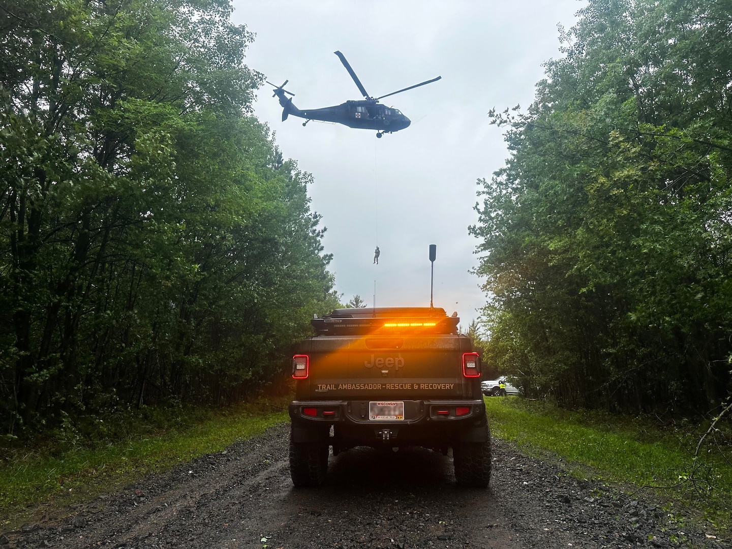 A Wisconsin Army National Guard UH-60 Black Hawk helicopter deploys its hoist capability during a search and rescue training exercise June 1 in Jackson County, Wis. The Black Hawk crew collaborated with Trail Ambassadors and the emergency management offices of Jackson County and the Ho-Chunk Nation. Photo courtesy Wisconsin Trail Ambassadors Program