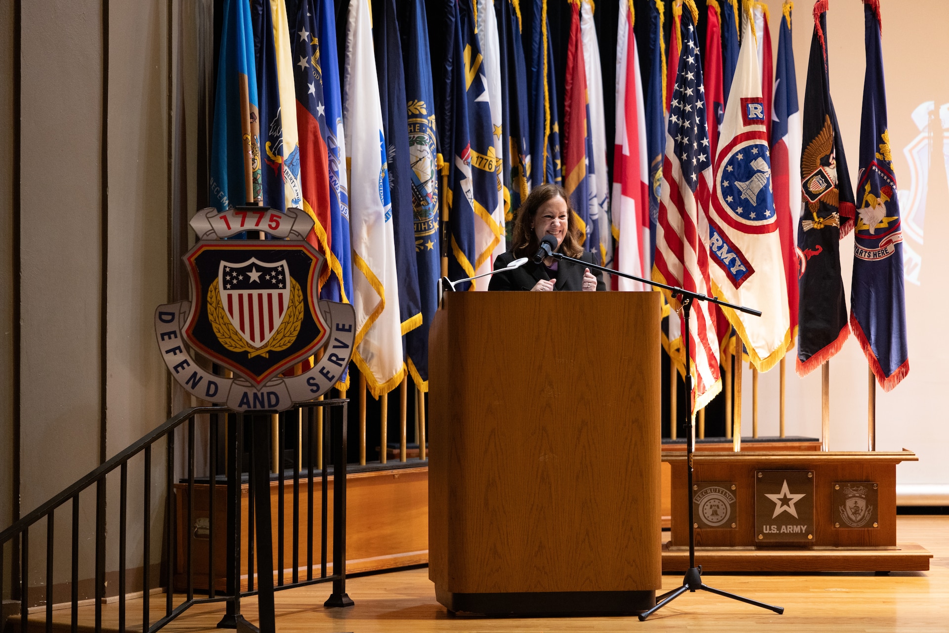 woman stands behind a podium.