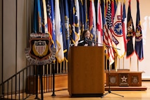 woman stands behind a podium.