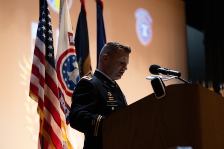 man wearing u.s. army uniforms stands behind a podium.
