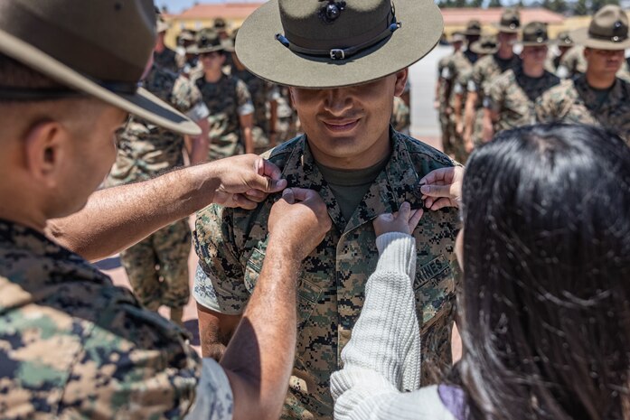 U.S. Marine Corps Staff Sgt. Jose Salcedo, a chief drill instructor with Kilo Company, 3rd Recruit Training Battalion, stands at attention while he is promoted to the rank of staff sergeant meritoriously at Marine Corps Recruit Depot San Diego, California, July 2, 2024. Salcedo was meritoriously promoted for his hard work, dedication to duty, and excelling beyond his peers.  Meritorious promotions are based on outstanding performance and the Marine's ability to take on more responsibility and authority. Nominees must also demonstrate leadership skills and be able to fulfill the duties of the next higher grade. (U.S. Marine Corps photo by Sgt. Jesse K. Carter-Powell)
