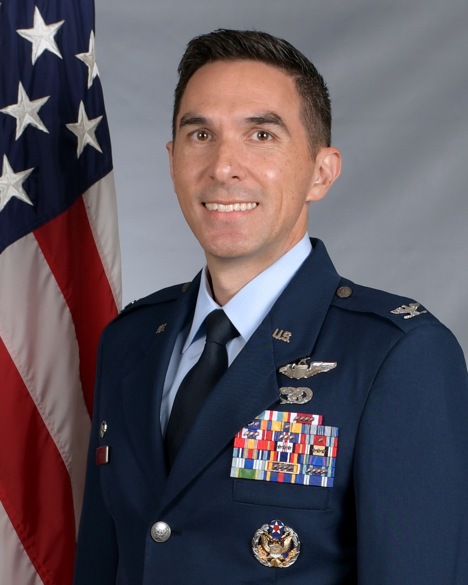A man in dress uniform smiles at the camera.