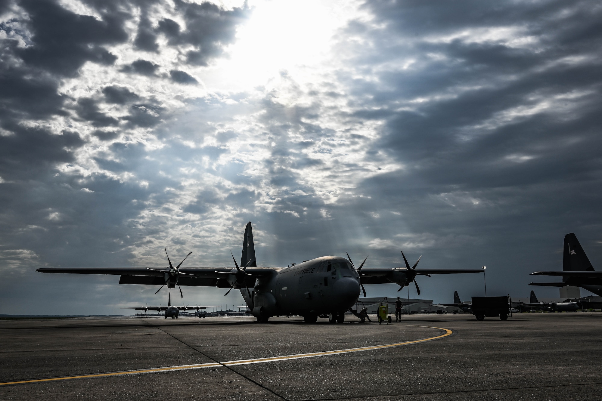 A military aircraft is backlit by sun rays.