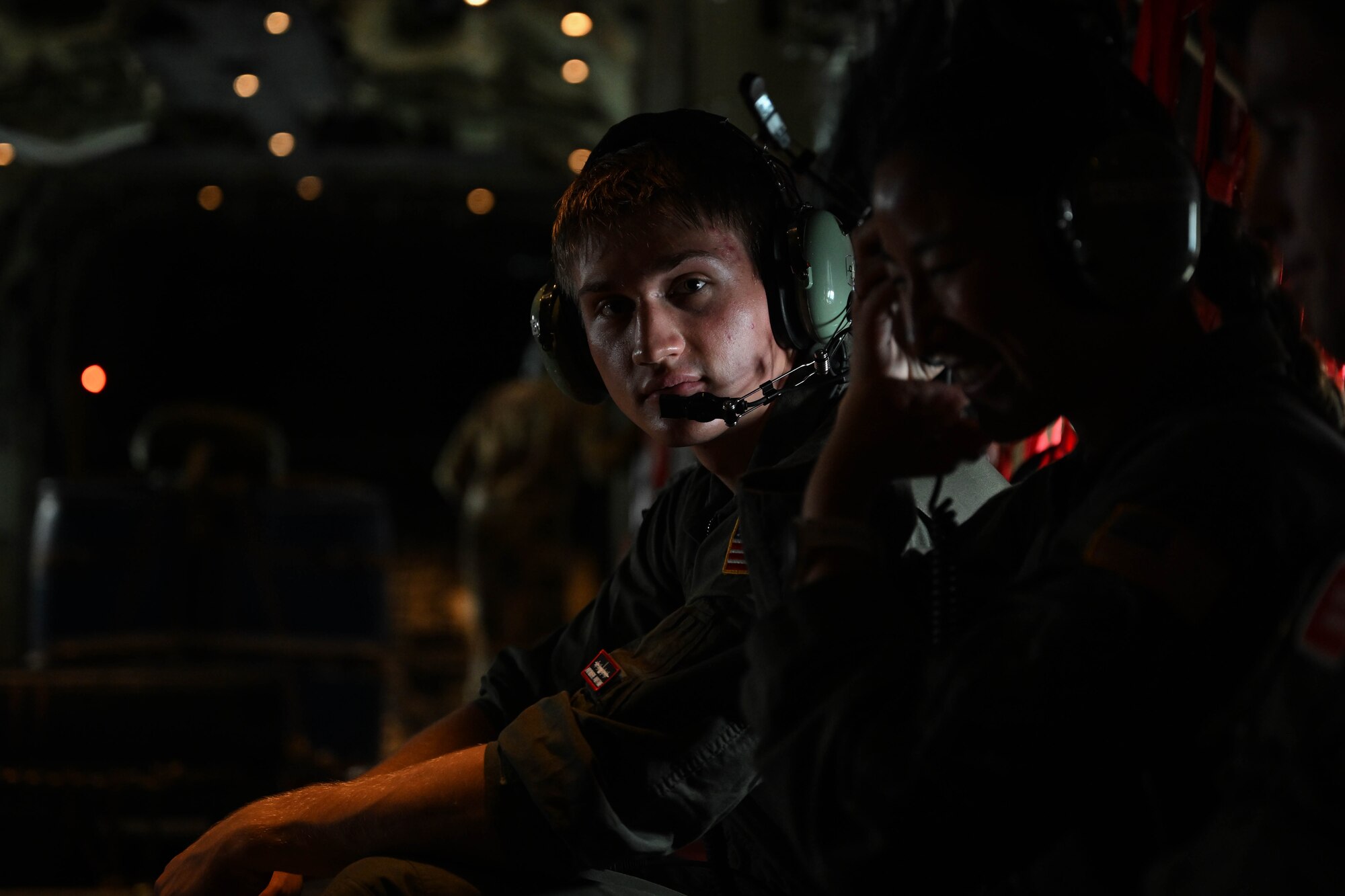 A man in uniform looks around the inside of a plane.