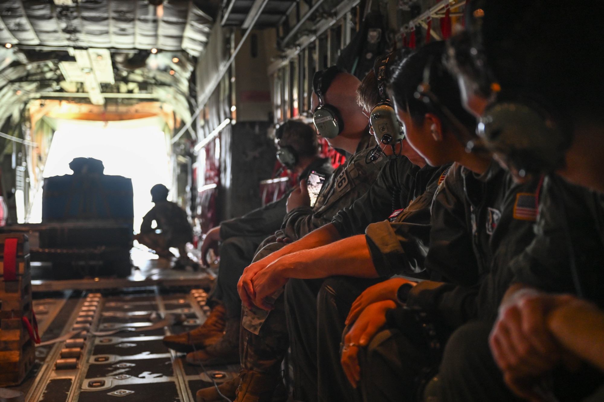 People in uniform watch another man in uniform.