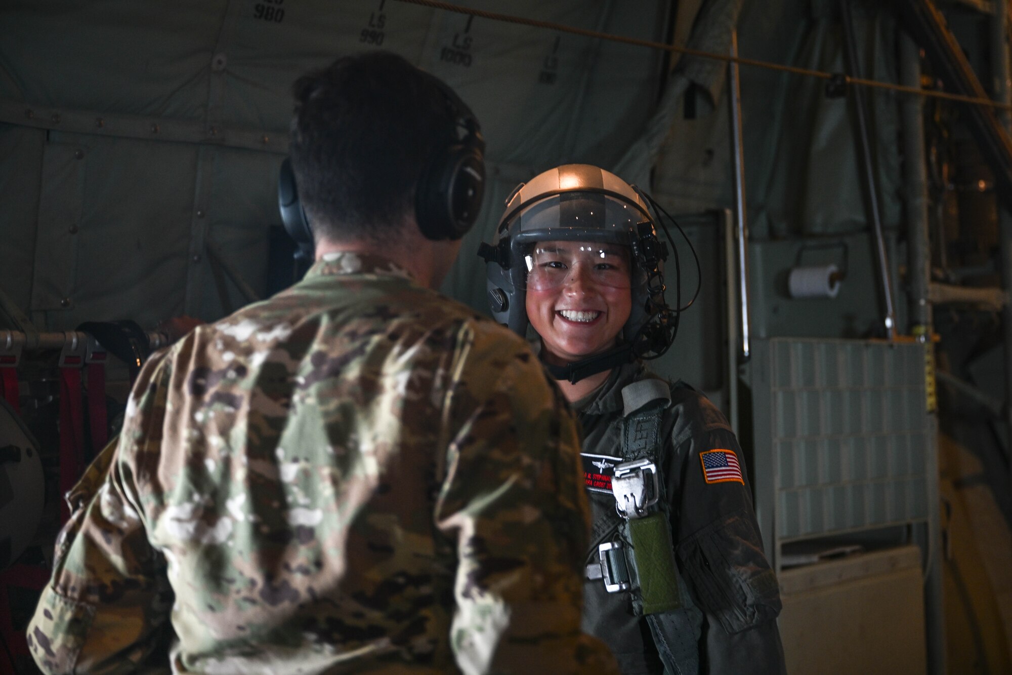 A female wearing a helmet smiles at the camera.