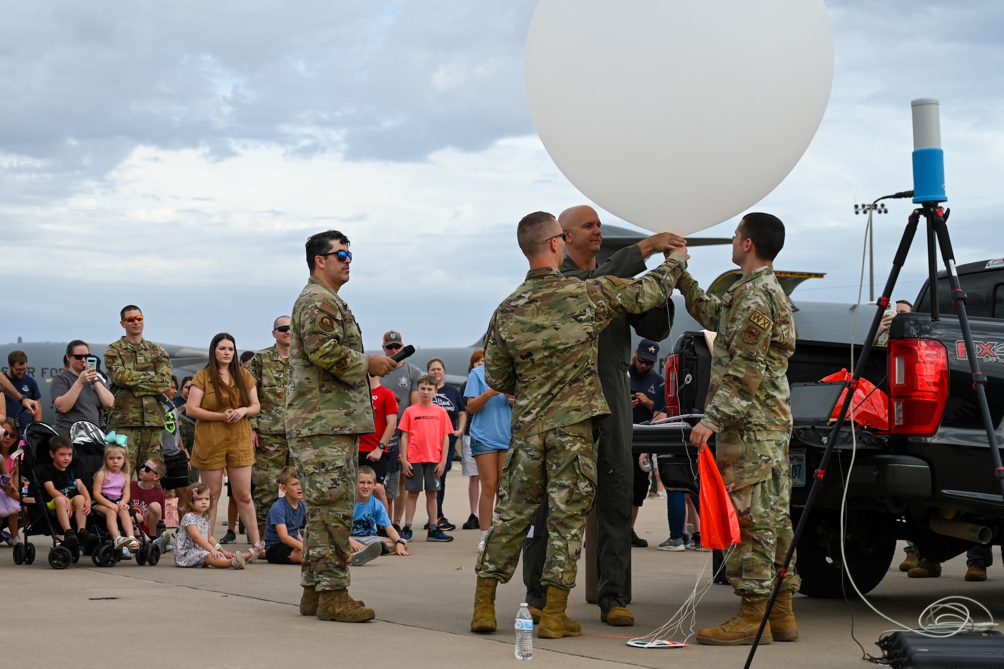 U.S. Air Force Col. Jefferey Marshall, 97th Air Mobility Wing commander, and Airmen from the 97th Civil Engineering Squadron Weather Flight inflate a high-altitude weather balloon to release at Altus Air Force Base, Oklahoma, July 3, 2024. The weather balloon captured data on the temperature dew point, pressure, wind speed, and wind direction to show children and families a small part of the Mighty 97th’s mission. (U.S. Air Force photo by Airman Lauren Torres)