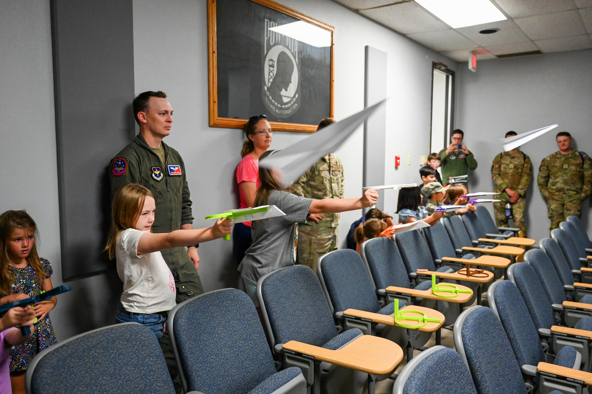 Children of 97th Air Mobility Wing Airmen fly paper airplanes during a bring your kid to work day event at Altus Air Force Base (AFB), Oklahoma, July 3, 2024. The 97th Training Squadron held a paper airplane contest for Altus AFB’s Bring Your Kids to Work Day. (U.S. Air Force photo by Airman 1st Class Jonah G. Bliss)