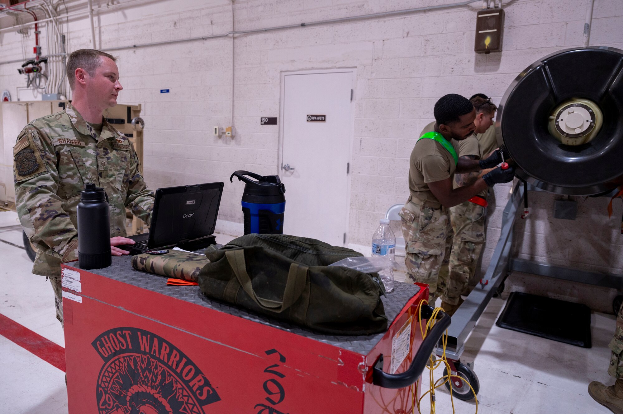 U.S. Air Force Staff Sgt. Shaun Shaffer, 49th Aircraft Maintenance Squadron dedicated crew chief, left, supervises a group of 49th AMXS Airmen as they install a panel at Holloman Air Force Base, New Mexico, July 10, 2024.