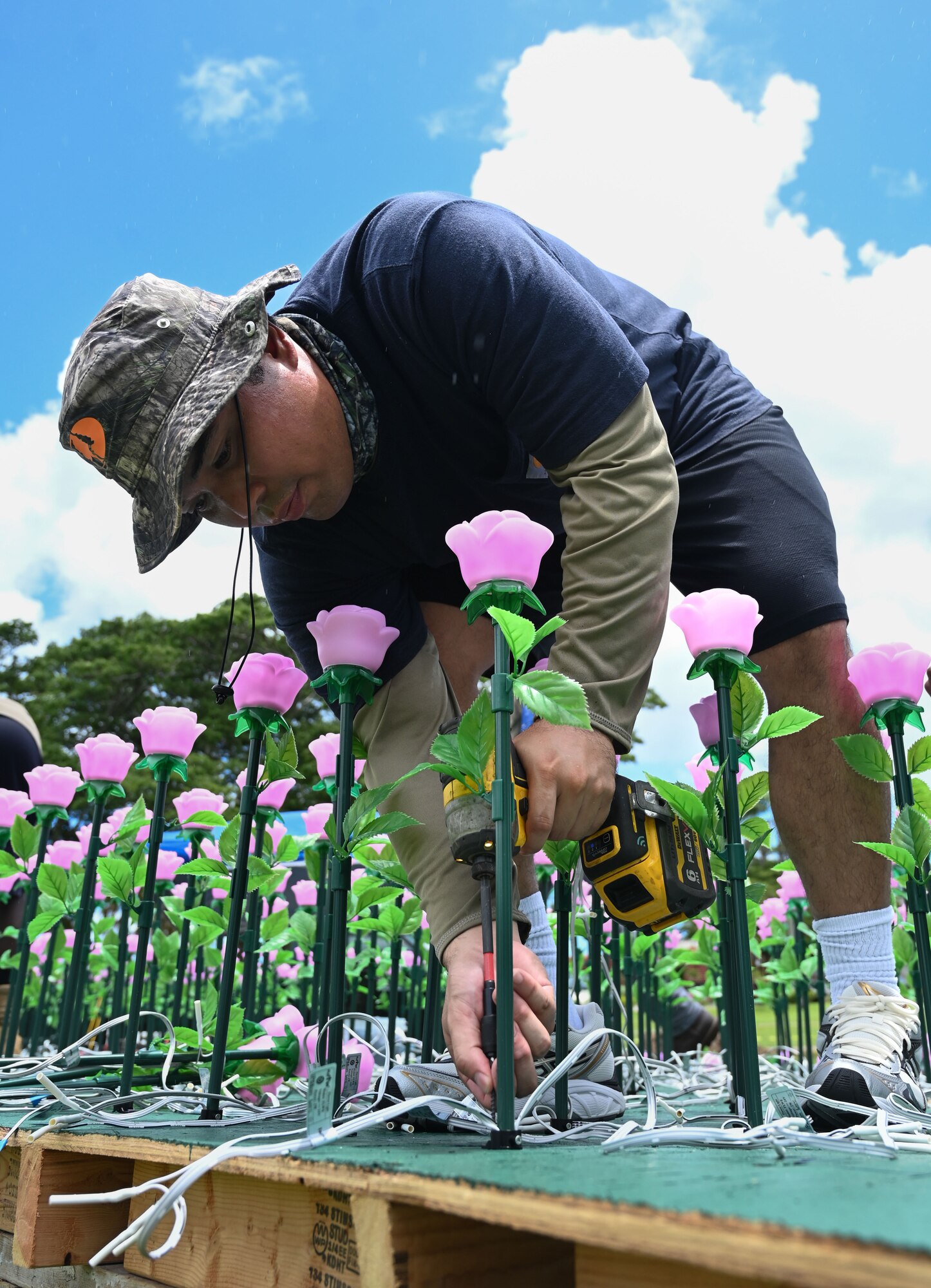 U.S. Air Force Airman 1st Class Brandon Fernandez assigned to the 554th Red Horse Squadron, Andersen Air Force Base, Guam, secures one of over 3,000 flower luminaries at the Plaza de España in Hagatña, July 9, 2024. As a Guam native, Fernandez took pride in this volunteer event part of the Sister Village Sister Squadron Program on Andersen. (U.S. Air Force photo by Airman 1st Class Natasha Ninete)