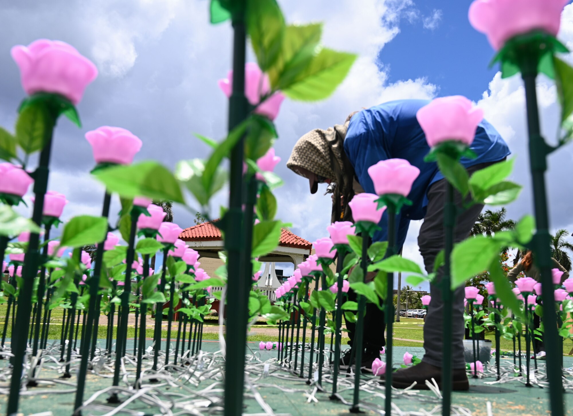 U.S. Air Force Airman 1st Class Jonathan Wadsworth assigned to the 554th Red Horse Squadron, Andersen Air Force Base, Guam, volunteers to arrange over 3,000 flower luminaries at the Plaza de España in Hagatña, July 9, 2024. Wadsworth helped secure the flowers onto a static display of Guam set to light up from July 19-21. (U.S. Air Force photo by Airman 1st Class Natasha Ninete).
