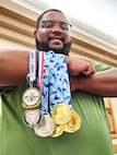 closeup of Jay with six medals hanging from his crossed right arm.