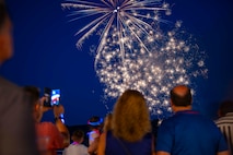 Sailors assigned to Naval Support Activity (NSA) Souda Bay, and their family members, watch fireworks an NSA Souda Bay Morale, Welfare, and Recreation Souda Bay Independence Day  celebration at the Hellenic Air Force, 115th Combat Wing Summer Officer's Club in Agios Onoufrios Beach , Greece, on June 28, 2024.
