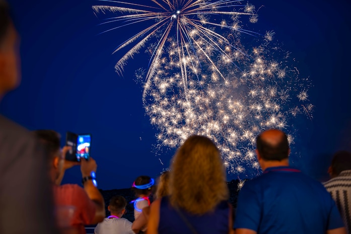 Sailors assigned to Naval Support Activity (NSA) Souda Bay, and their family members, watch fireworks an NSA Souda Bay Morale, Welfare, and Recreation Souda Bay Independence Day  celebration at the Hellenic Air Force, 115th Combat Wing Summer Officer's Club in Agios Onoufrios Beach , Greece, on June 28, 2024.