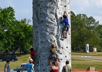 Kids climb a rock wall