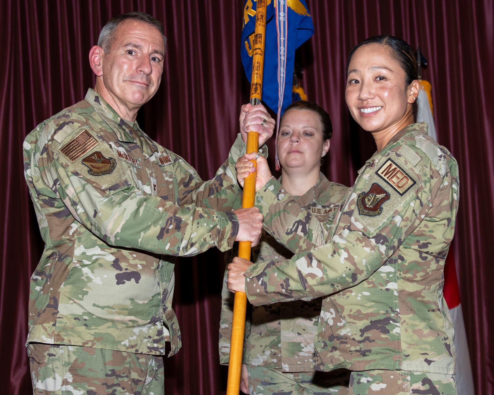 Incoming 374th Operational Medical Readiness Squadron commander, Kimberly McCoy-Singh receives the guidon as she takes command of the squadron.