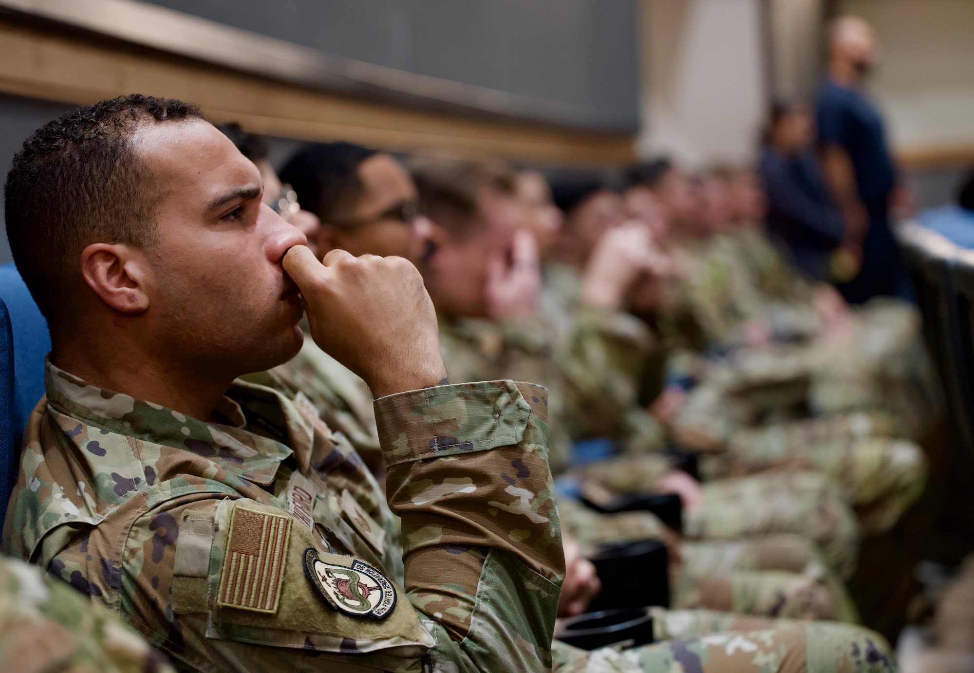 Airmen assigned to the 8th Fighter Wing listen as Chief Master Sgt. Jeremiah Ross, 7th Air Force command chief, addresses members of the Wolf Pack during a noncommissioned officer all-call at Kunsan Air Base, Republic of Korea, July 10, 2024.