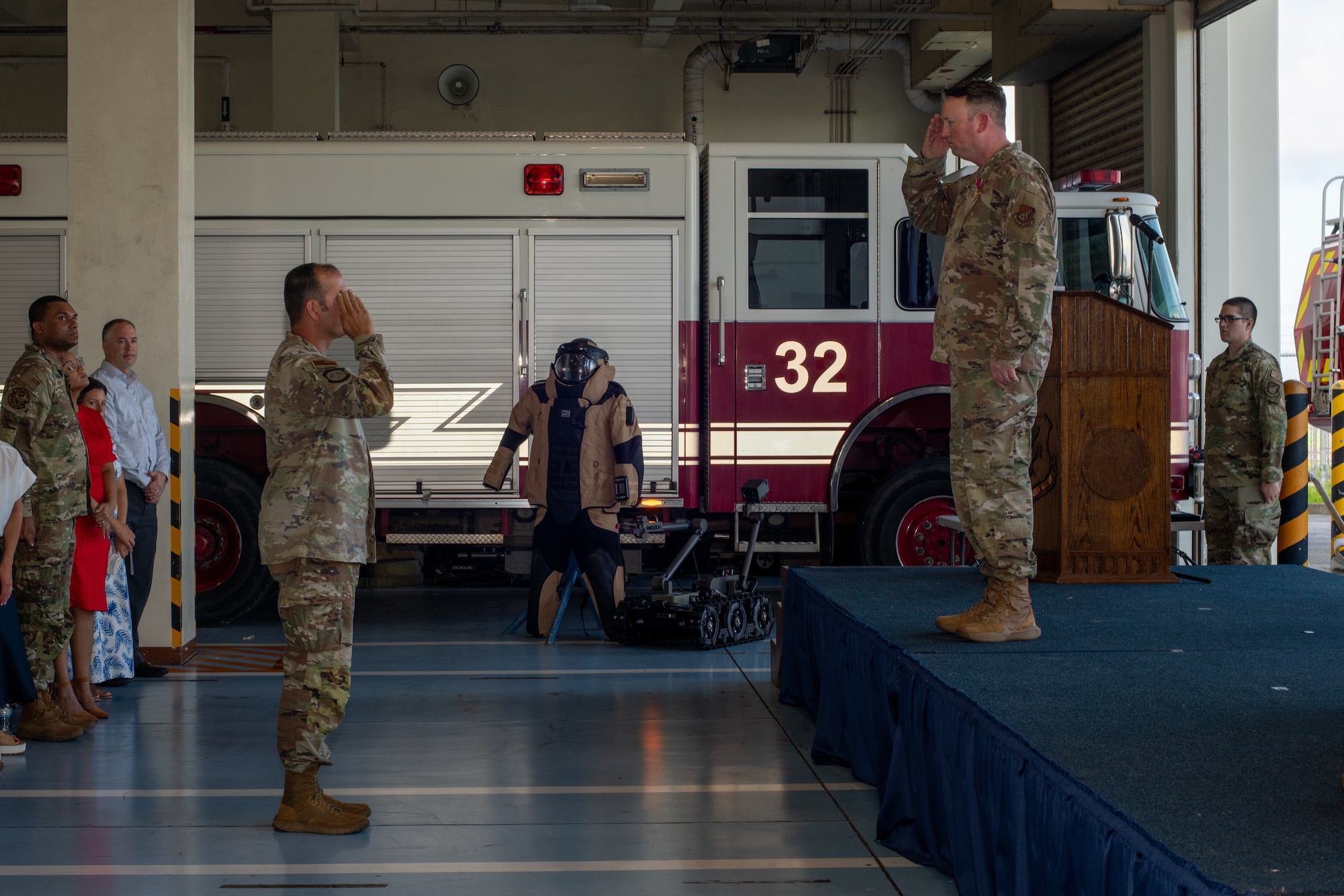 military member salutes other military member on a stage